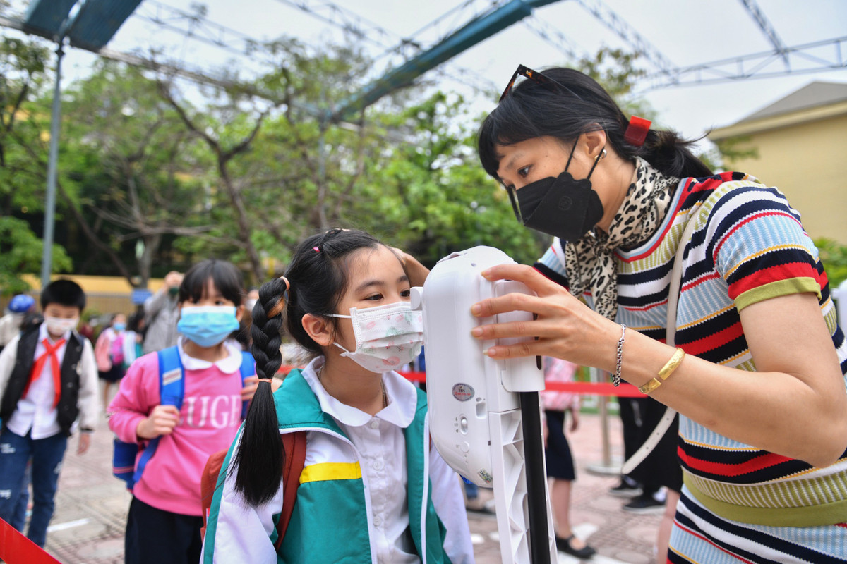 Các em khi đến trường vẫn phải thực hiện quy tắc đeo khẩu trang trong suốt quá trình học, khi vào lớp đứng xếp hàng giãn cách, đo thân nhiệt và sát khuẩn tay.