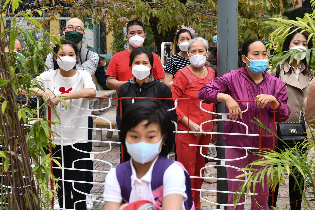 Nhiều phụ huynh và người nhà nán lại đứng ngóng các con từ phía ngoài hàng rào.