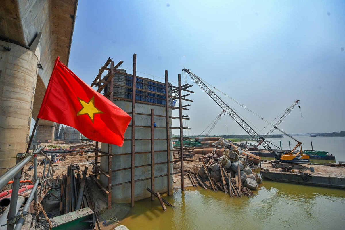 Các công nhân đang hoàn thiện những công đoạn cuối của một trụ cầu vượt dòng chính sông Hồng.