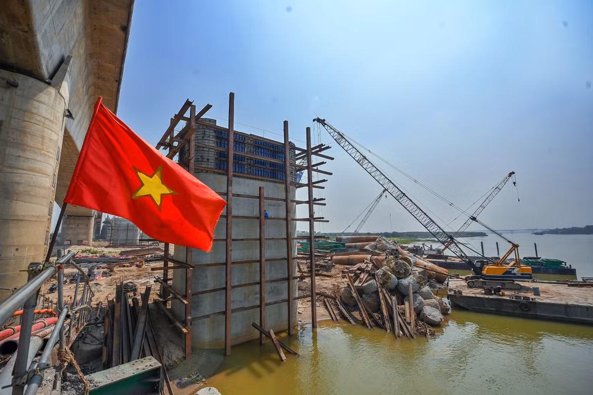 Các công nhân đang hoàn thiện những công đoạn cuối của một trụ cầu vượt dòng chính sông Hồng.