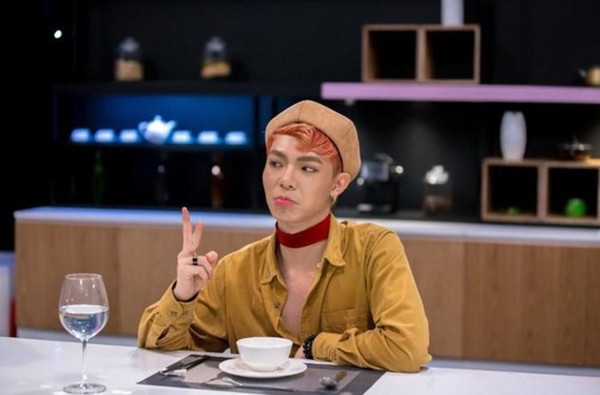 Erik từng trang điểm phong cách unisex khá lòe loẹt, đeo vòng choker đỏ chót lạc lõng hoàn toàn với trang phục.