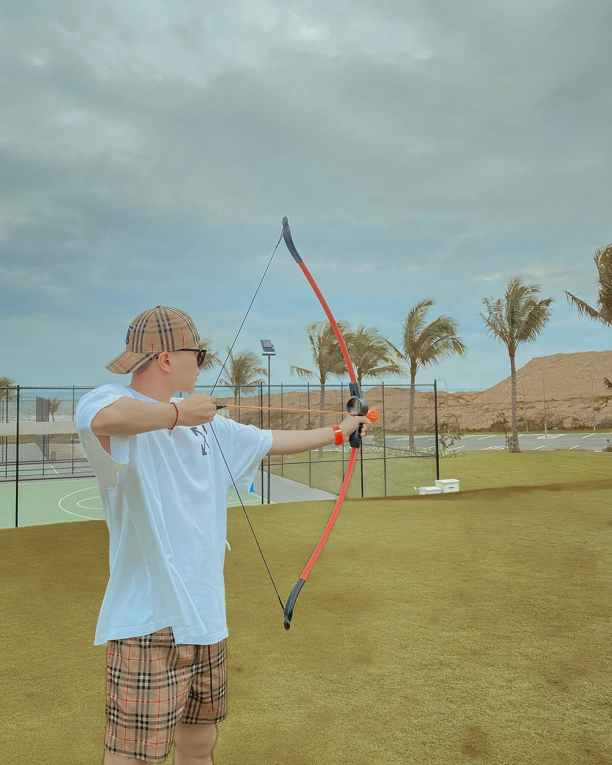 Trịnh Thăng Bình khoe ảnh chơi bắn cung trong chuyến nghỉ dưỡng.