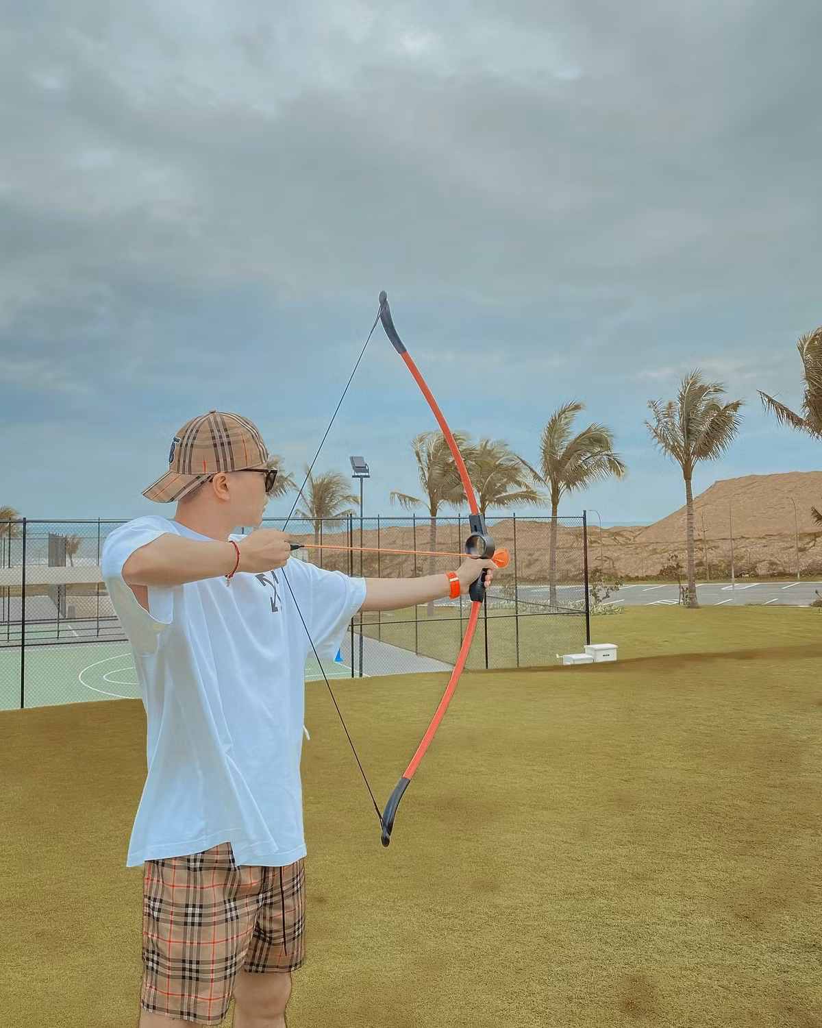 Trịnh Thăng Bình khoe ảnh chơi bắn cung trong chuyến nghỉ dưỡng.