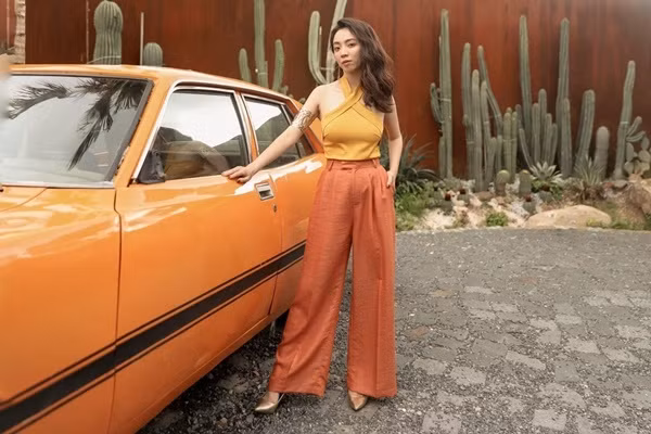 Diễn viên hài Thu Trang chia sẻ bộ ảnh thời trang mang đậm màu sắc nhiệt đới với tone màu cam, vàng nổi bật. Phụ kiện vòng tay to bản tăng thêm vẻ cá tính cho Thu Trang, cô cũng chọn kiểu tóc xoăn sóng phóng khoáng phù hợp với phong cách của trang phục.