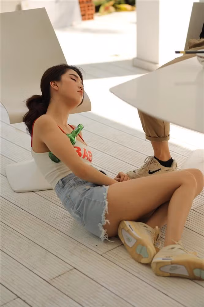 Chân dài "phê" đến mức ôm chai rượu nằm vật trên nền đất.