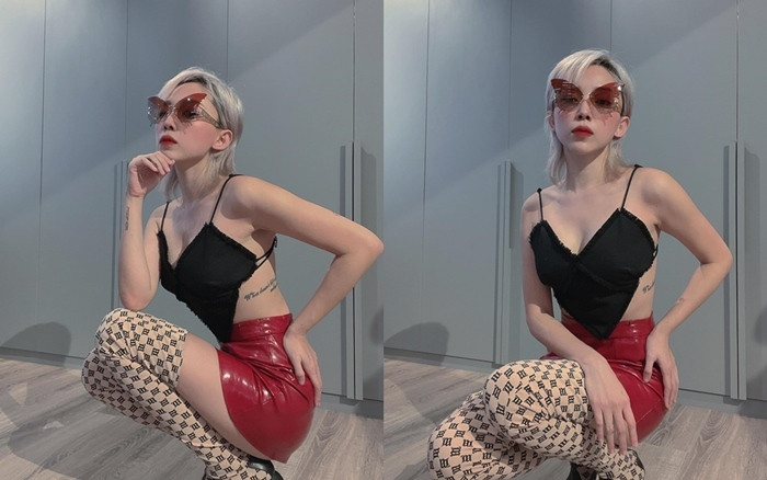 Bà xã Touliver thể hiện dấu ấn rõ nét khi phối áo 2 dây hình trái tim đen tuyền, chân váy mini da đỏ và boots đùi họa tiết. Cặp kính màu mắt nâu đỏ đã khiến trang phục thêm ấn tượng.