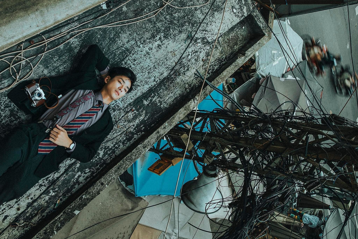 Trần Nghĩa tạo dáng bên dây điện.