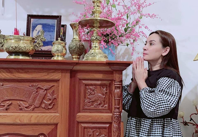 Phi Nhung chắp tay khấn nguyện trong ngày giỗ mẹ. Nữ ca sĩ tự tay cắm hoa Tigon trưng bàn thờ - loài hoa mẹ cô yêu thích lúc còn sống.