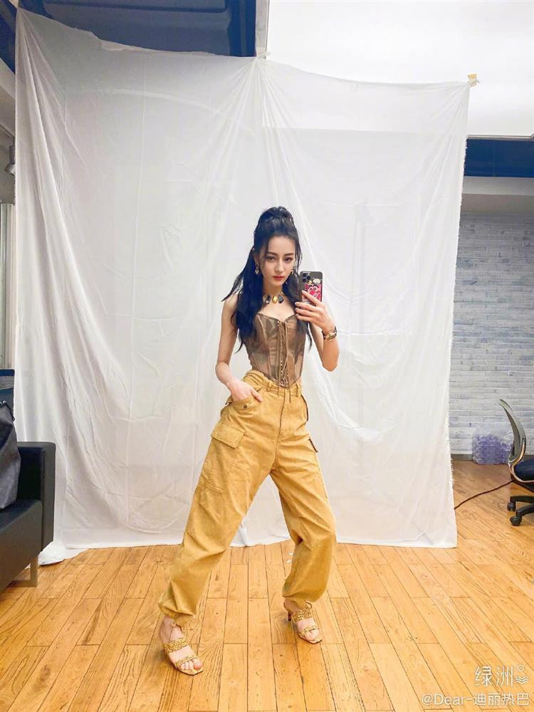 Khác với hình ảnh lộng lẫy trong những bộ đầm công chúa thường thấy, dự chương trình này, Nhiệt Ba lên đồ cá tính với áo corset kết hợp quần jogger, dép cao gót phủ sắc vàng đồng điệu.