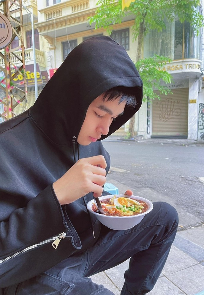 Jun Phạm thưởng thức món cháo đậu cà trong thời tiết se lạnh của buổi sớm mai Hà Nội.