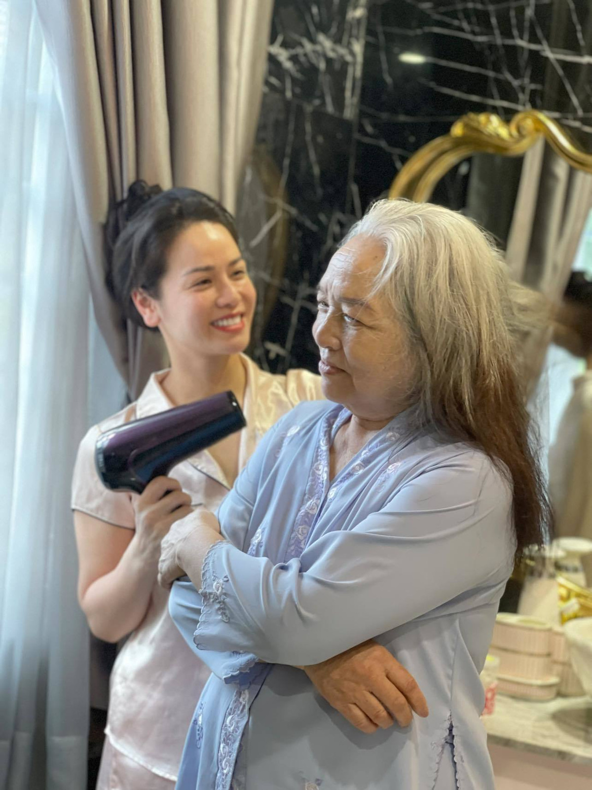 Nhật Kim Anh sấy tóc cho mẹ.