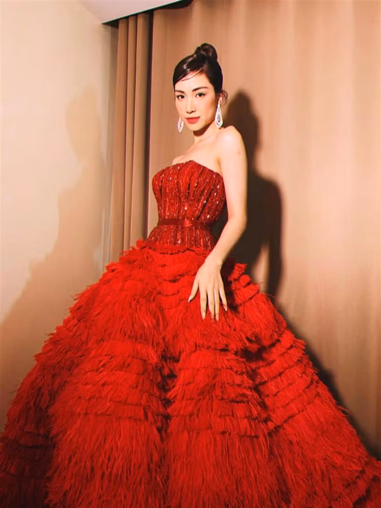 Ca sĩ Hòa Minzy makeup son đỏ, vừa tông xuyệt tông màu váy, vừa giúp gương mặt thêm thần thái, cuốn hút. Dù chỉ cao 1m55 song giọng ca "Không thể cùng nhau suốt kiếp" vẫn mạnh dạn "đụng hàng" cùng dàn chân dài Vbiz.