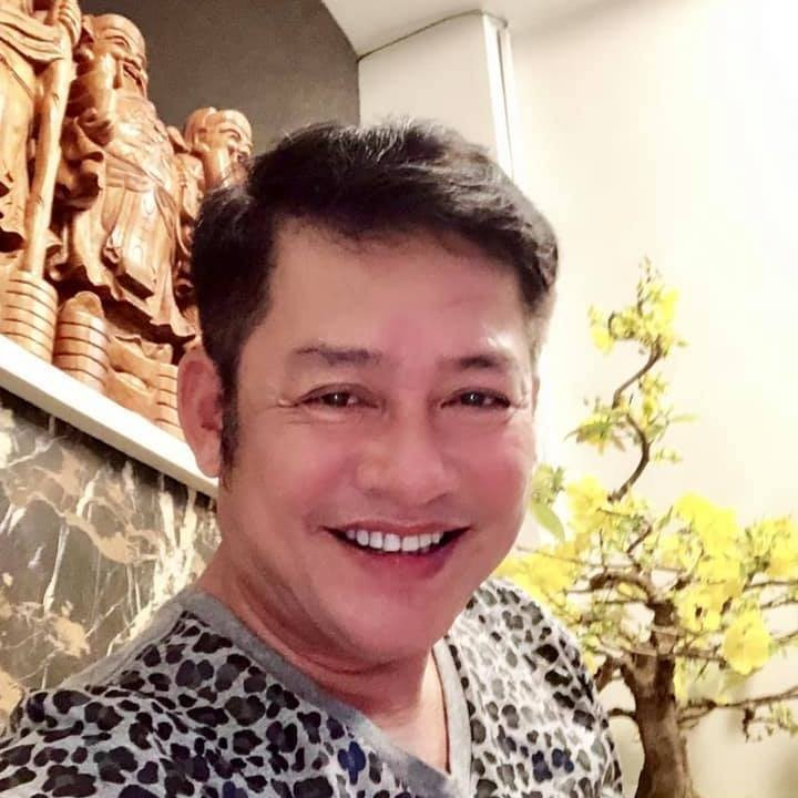 Nghệ sĩ Tấn Beo cười tươi bên chậu mai vàng.