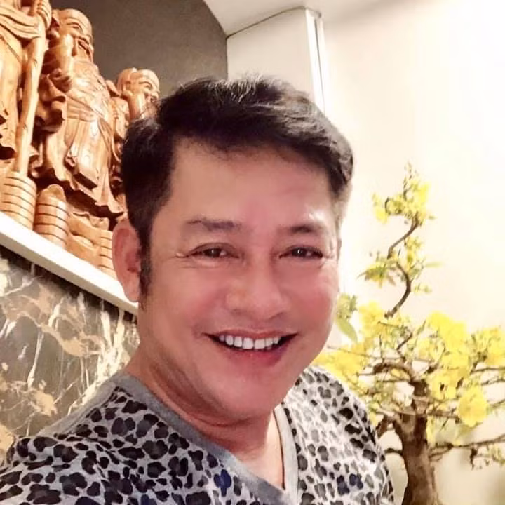 Nghệ sĩ Tấn Beo cười tươi bên chậu mai vàng.