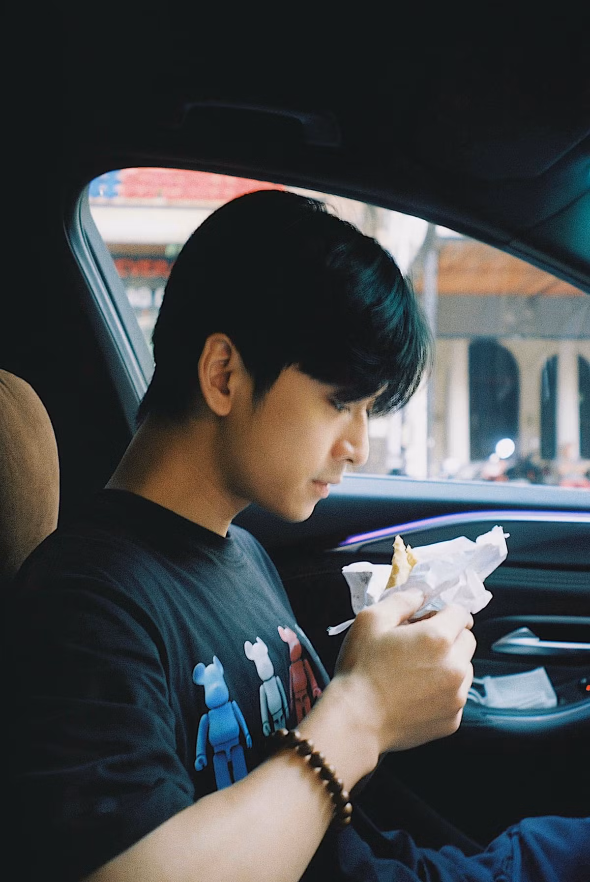 Trần Nghĩa ăn vội trong xe.