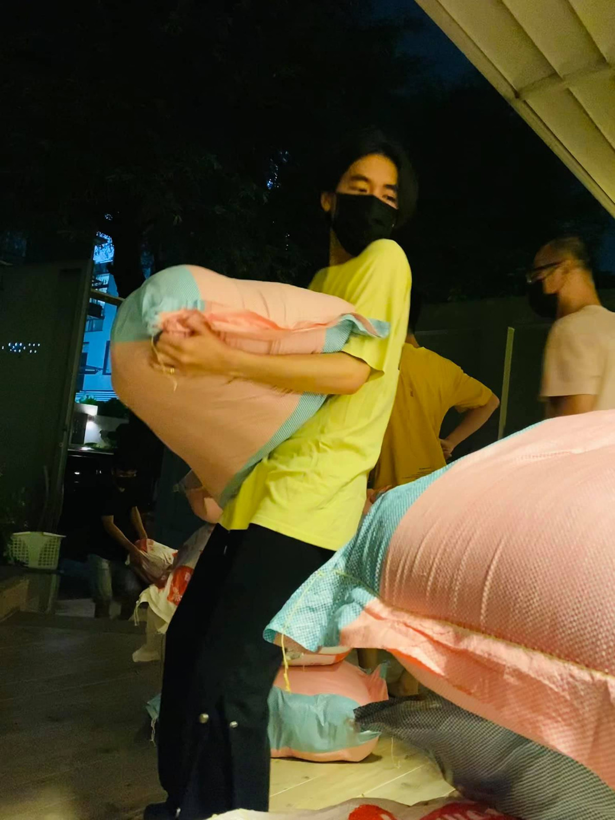 K-ICM chật vật vác bao gạo 50 kg.