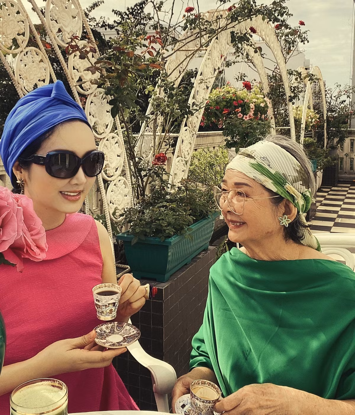 Mẹ con Giáng My thưởng trà bánh ngoài vườn.