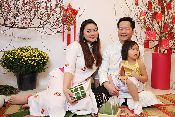 Đặc biệt, vợ chồng Phan Như Thảo và người thân trong gia đình cùng diện áo dài cách tân trong khi thực hiện công đoạn gói bánh. Trong khi mẹ và các cô, các mợ diện áo dài màu sắc thì người đẹp lựa chọn áo dài trắng có họa tiết cùng quần suông đỏ.