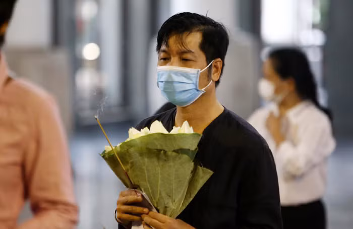 Một người bạn ôm hoa sen trắng tiễn biệt hoa hậu.