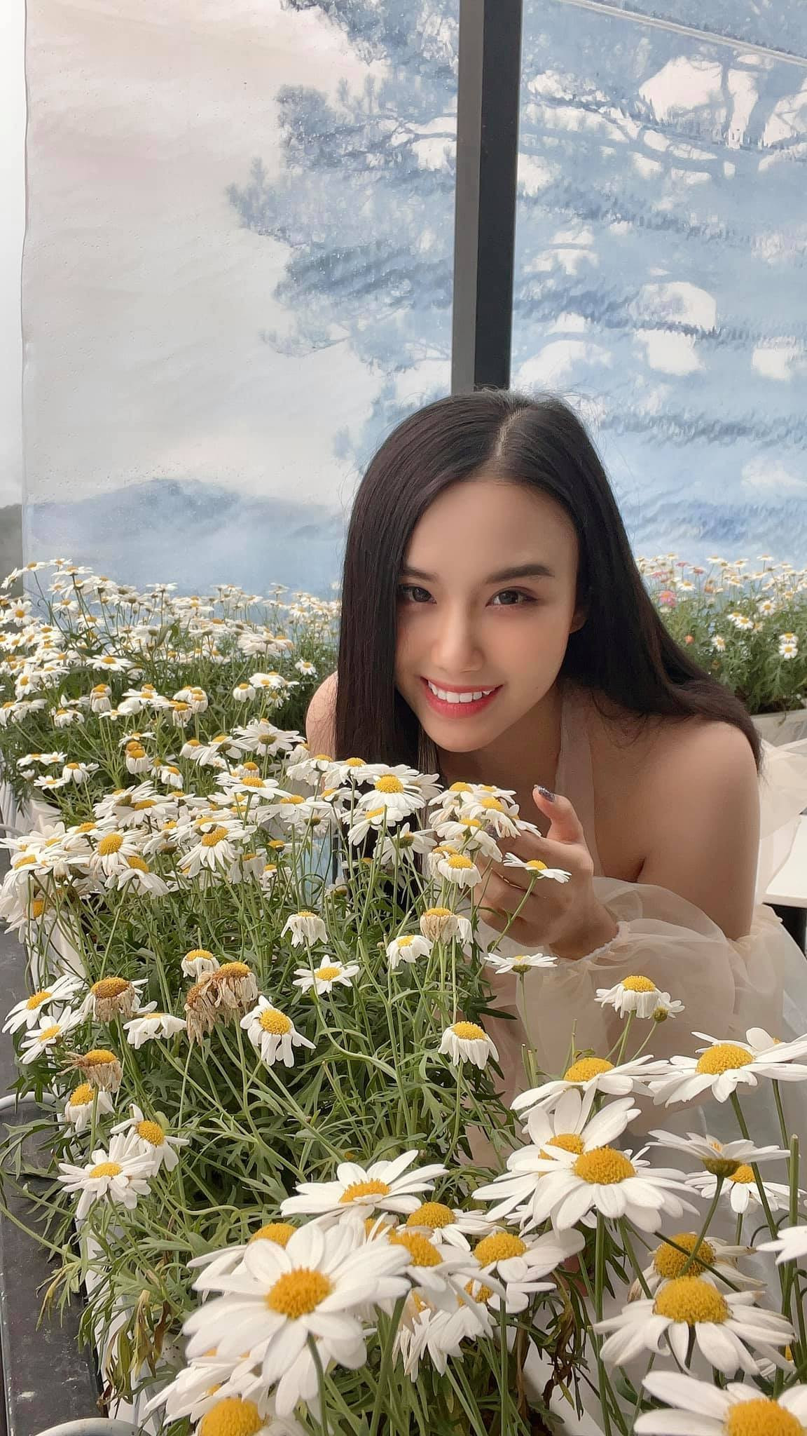 Linh Miu chụp ảnh bên hoa.