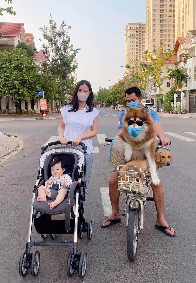 Đông Nhi đẩy xe đưa con gái đi dạo quanh khu phố. Nữ ca sĩ thích thú với chú chó to của người bạn hàng xóm.