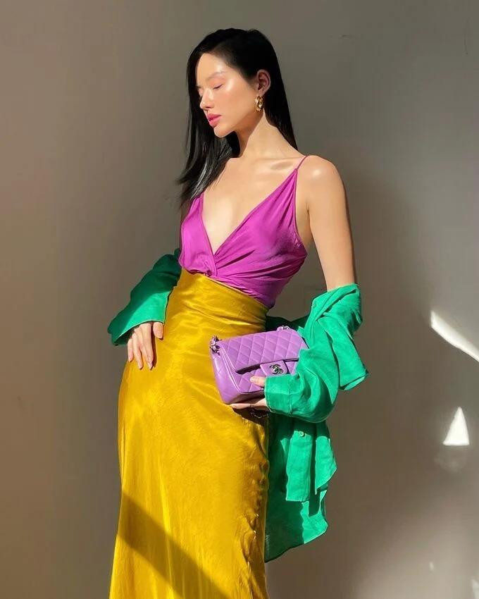 Khánh Linh gây ấn tượng với cách mix đồ đầy màu sắc sặc sỡ. Nàng mẫu khéo léo phối áo dây màu tím cùng chân váy dài màu neon, nhấn nhá bằng áo sơ mi màu xanh khoác hờ hững.