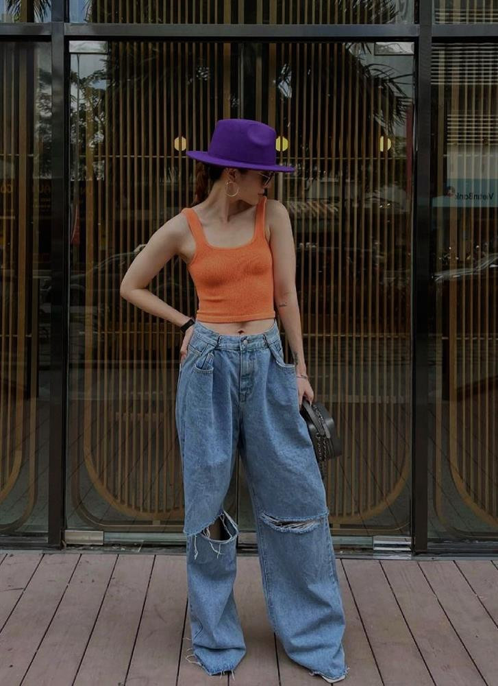 ến Nhi “bùng nổ” phong cách với áo tank màu cam và quần jeans ống loe, rách gối bụi phủi. Chiếc mũ fedora màu tím là phụ kiện F5 trang phục ấn tượng.