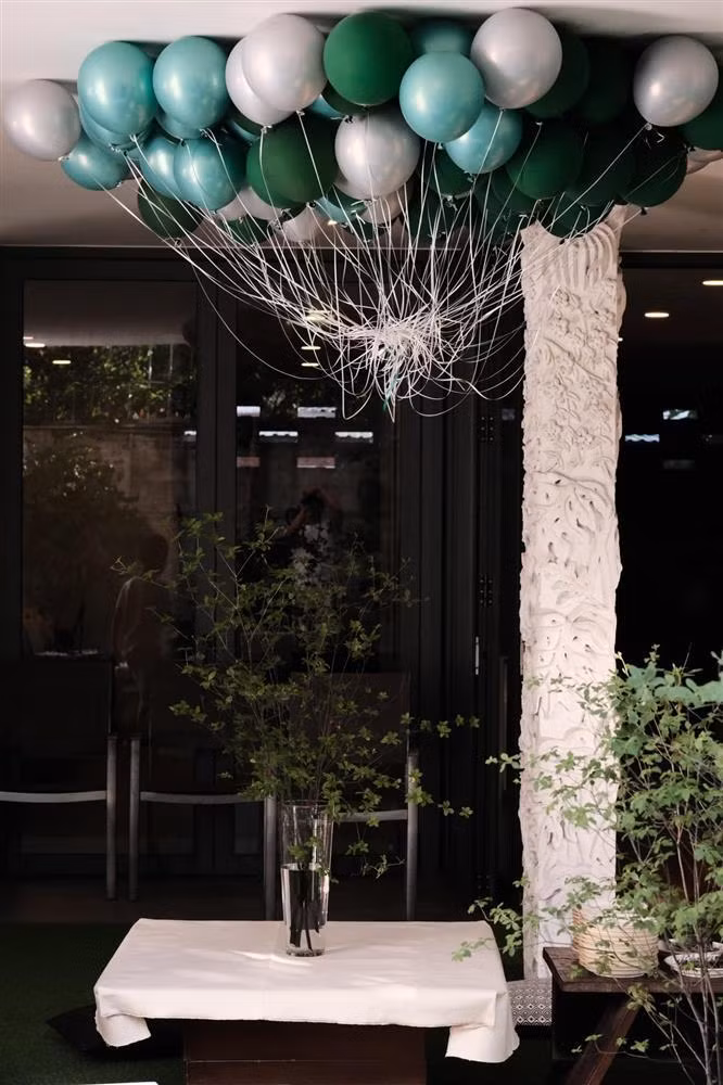 Bóng bay và những cành cây xanh tươi được bố trí tinh tế trên những bàn tiệc.