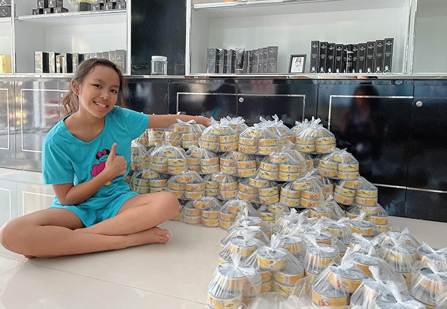 Việt Hương đăng ảnh con gái phụ vợ chồng cô gói quà trao tặng người nghèo.