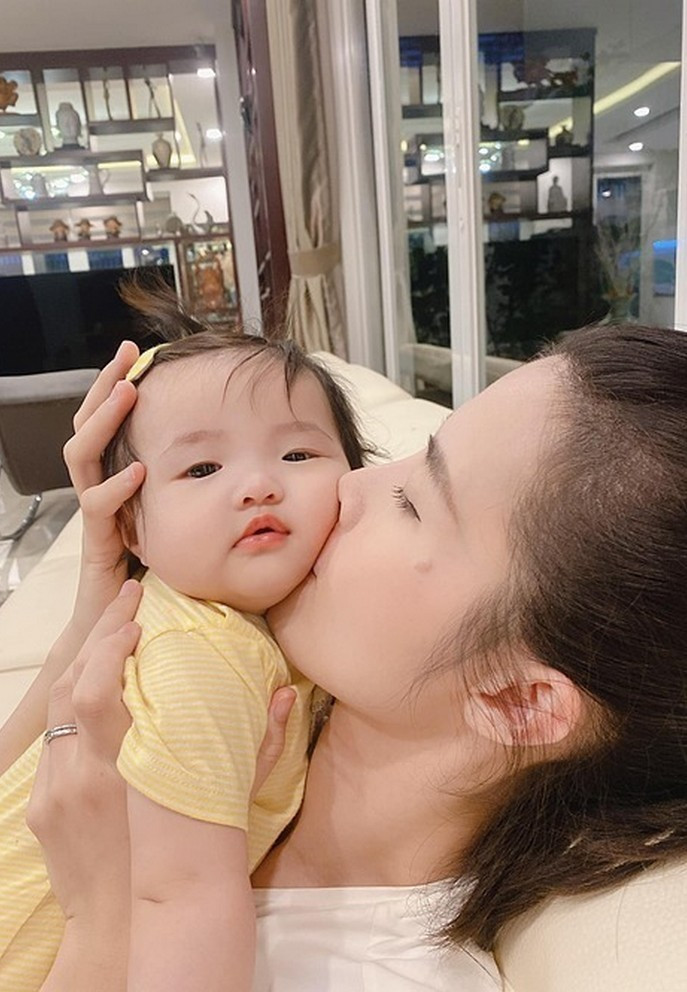 Con gái Đông Nhi biểu cảm lạnh lùng mặc cho mẹ hôn liên tục vào má.