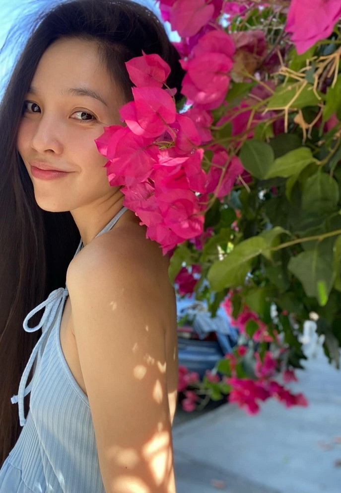 Hiền Thục ngẫu hứng tạo dáng bên hoa, khoe nhan sắc trẻ trung.