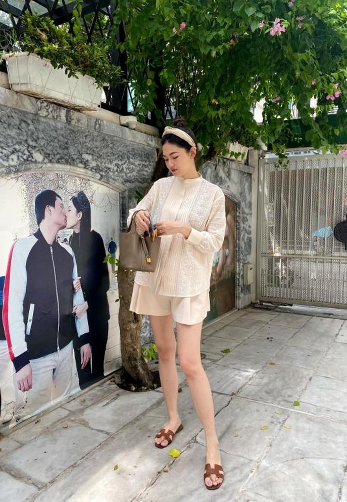 Á hậu Thanh Tú tạo dáng trong một góc biệt thự. Tường nhà nữ diễn viên in hình lãng mạn giữa cô và ông xã.