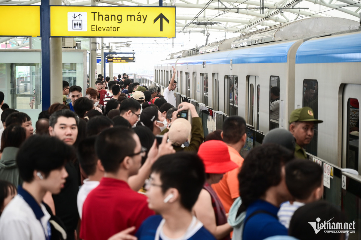 Hành khách đổ ra khu vực tàu di chuyển, chờ lên tàu. Nhân viên metro phải dùng loa nhắc nhở người dân không tới gần đường ray.