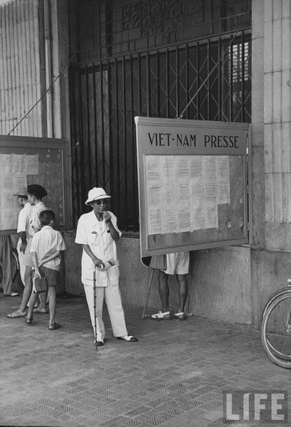 Người dân đọc báo tại một góc phố.