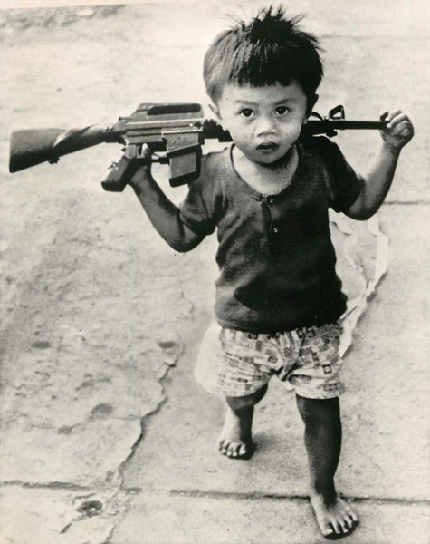 Một em bé cầm khẩu súng đồ chơi "nhái" súng M16 của Mỹ trên đường phố Sài Gòn, ngày 6/1/1973.