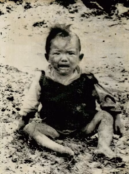 Em bé ngồi khóc trên mặt đường ở Nam Quảng Trị sau khi chiếc xe chở em cùng đoàn người di tản bị trúng mìn và nổ tung, ngày 27/4/1972. 40 người đã chết và hàng chục người khác bị thương trong vụ việc này.