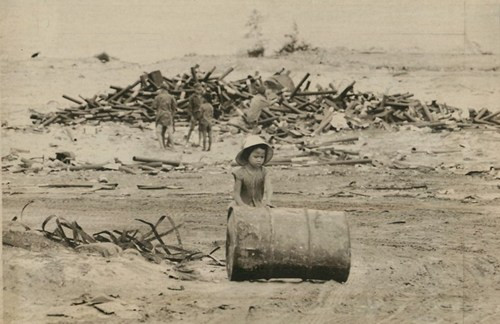 Bé gái lăn chiếc thùng phi từ bãi rác để đem bán phế liệu ở Đà Nẵng, ngày 27/6/1971.