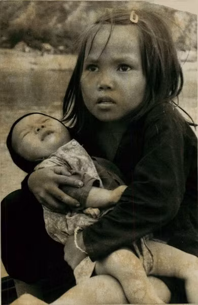 Một bé gái ôm đứa em trai trên chiếc thuyền vượt con sông phía Nam Đà Nẵng để di tản khỏi cuộc giao tranh diễn ra ở Đà Nẵng, ngày 10/8/1974.