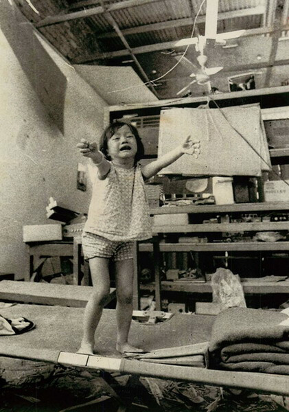 Một bé gái giơ tay cầu cứu trong ngôi nhà vừa bị trúng đạn rốc-két, Biên Hòa ngày 1/10/1973.