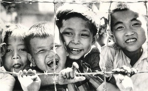 Trẻ em hiếu kỳ tụ tập ngoài hàng rào thép gai của một trại lính Mỹ ở Tri Tôn, An Giang, 21/11/1968.