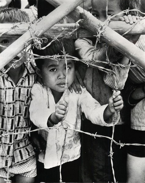Những đứa trẻ phía sau hàng rào thép gai của một trại dành cho người di tản ở Đà Nẵng, 13/12/1967.