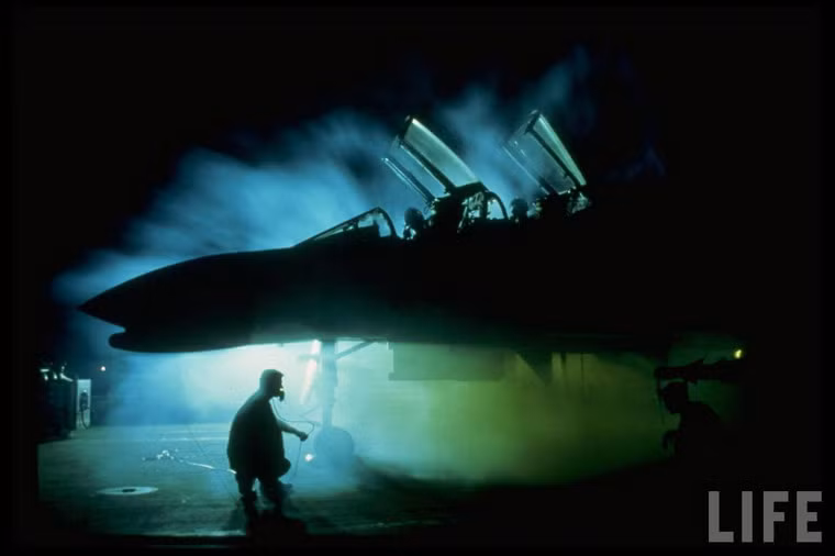 Phi hành đoàn và nhân viên mặt đất đang chuẩn bị cho một chuyến xuất kích của chiến đấu cơ F-4 Phantom vào buổi sáng sớm tại sân bay Phan Rang.