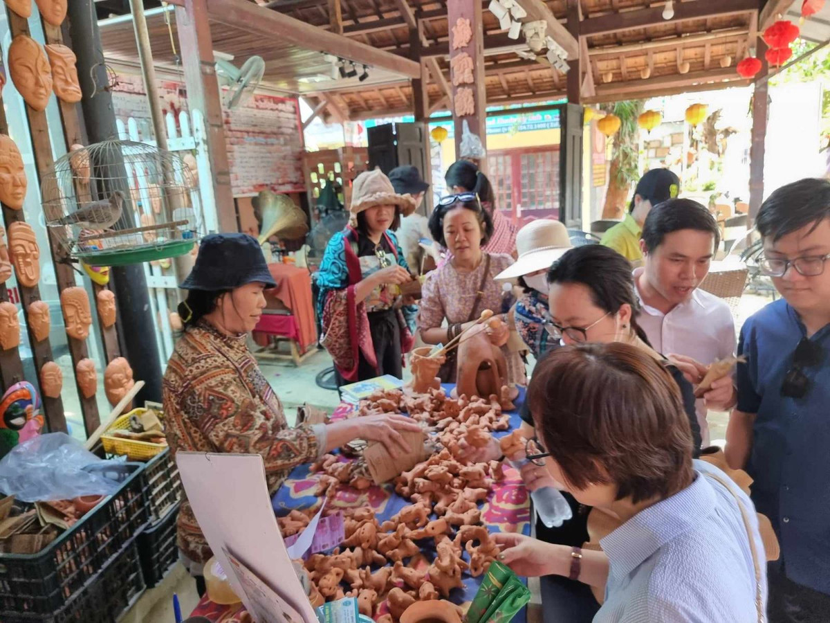 Du khách chọn mua sản phẩm lưu niệm từ gốm.