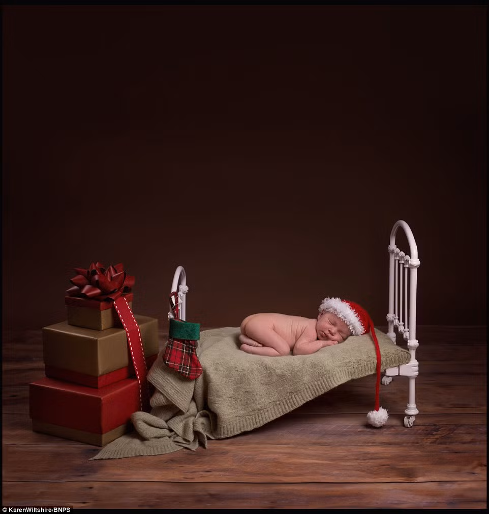 Em bé đang say giấc nồng bên cạnh đống quà Noel.