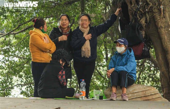 Nhóm phụ nữ trung niên đứng trò chuyện ở khu vực Bờ Hồ, nhiều người không đeo khẩu trang.