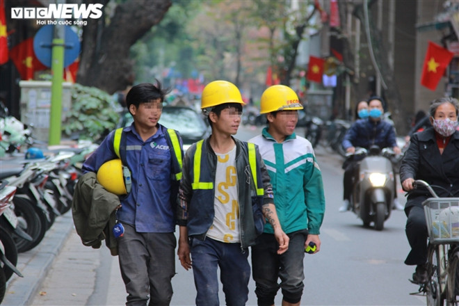 Nhóm công nhân xây dựng cười đùa, thản nhiên dạo phố mà không đeo khẩu trang.