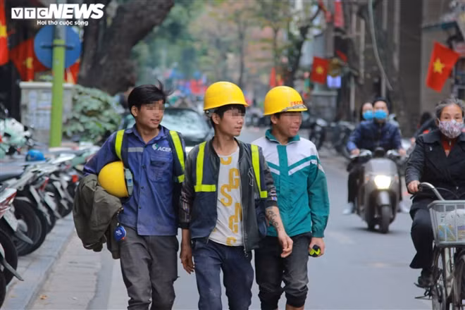 Nhóm công nhân xây dựng cười đùa, thản nhiên dạo phố mà không đeo khẩu trang.