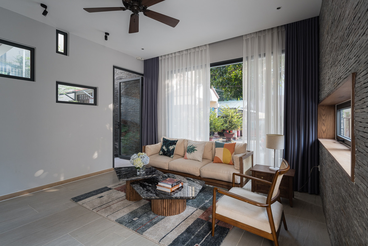 Do vị trí xây dựng sát kề căn nhà của bố mẹ nên công trình có thể tận dụng và tạo ra không gian mở với hàng rào sắt thấp. Từ đó sử dụng được tối đa nguồn sáng tự nhiên cho các khu vực phòng, đặc biệt là phòng khách, phòng bố mẹ, và bếp ăn.