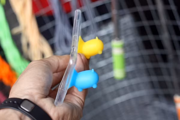 Những chú heo ngộ nghĩnh được gắn hút chặt vào vỏ bảo vệ bằng cao su của điện thoại nhằm dựng điện thoại nằm nghiêng.