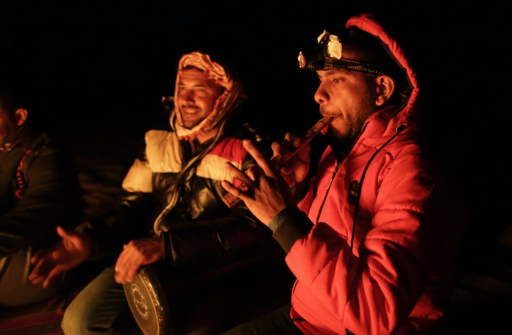 Một hướng dẫn viên trình diễn nhạc cụ dân tộc trong đêm lửa trại.